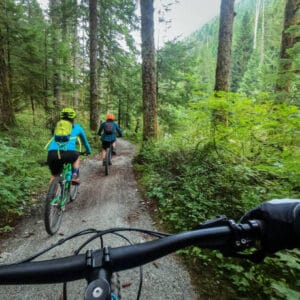 Multi-ethnic family riding on single track trail.  North Vancouver, British Columbia, Canada.
